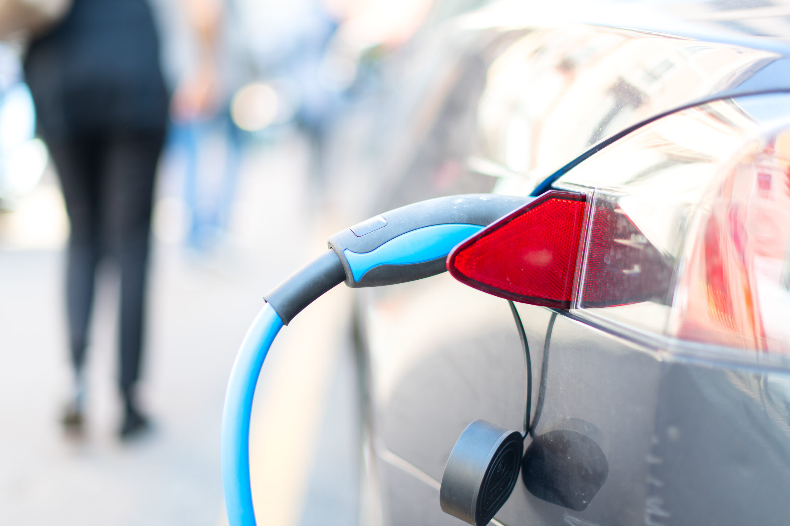 Electric vehicle plugged into a home wall charger in a residential garage
